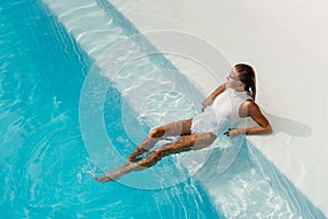 Young woman relaxing in swimming pool on summer vacation.