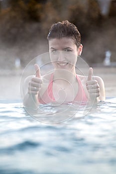 Young woman relaxing in thermal pool.