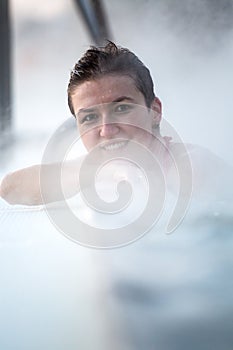 Young woman relaxing in thermal pool.