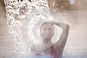 Young woman relaxing in thermal pool.