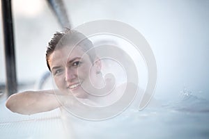 Young woman relaxing in thermal pool.