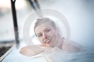 Young woman relaxing in thermal pool.