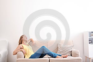 Young woman relaxing under air conditioner