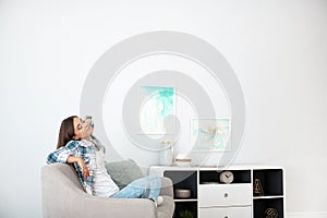 Young woman relaxing under air conditioner