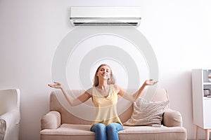 Young woman relaxing under air conditioner