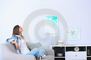 Young woman relaxing under air conditioner