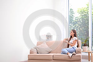 Young woman relaxing under air conditioner