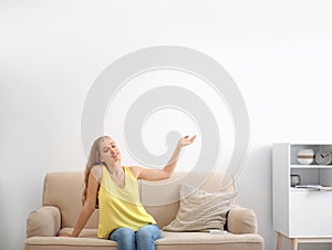 Young woman relaxing under air conditioner