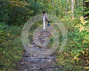 Young woman relaxing, walking in forest preserve