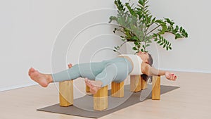 Young woman relaxing on the yoga blocks in the savasana pose in yoga studio