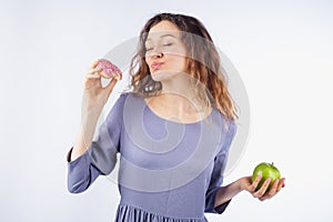 Young woman with relish eating a donut. Concept of harmful nutrition and diet