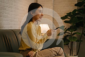 Young woman with remote control watching tv