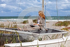 Young Woman Remote Working On Line Using Laptop On Boat At Beach