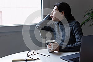 Young woman remotely working on the computer in his home office