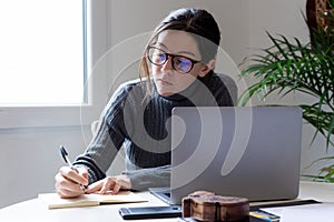 Young woman remotely working on the computer in his home office