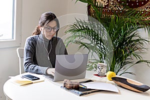 Young woman remotely working on the computer in his home office
