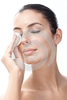 Young woman removing eye makeup