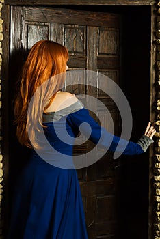 Young woman in renaissance dress open door