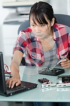 young woman repairing computer at office