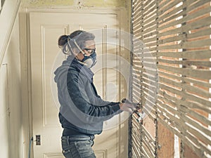 Young woman repairing wattle and daub wall