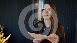 Young woman in a restaurant. A beautiful girl reads the menu, chooses food.