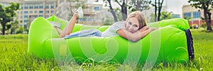 Young woman resting on an air sofa in the park. BANNER, long format