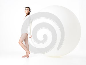 Young woman resting on big, white balloon