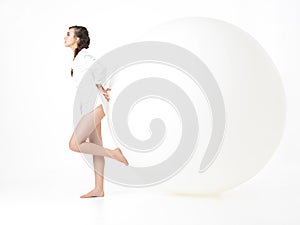 Young woman resting on big, white balloon