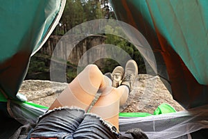 Young woman resting in camping tent,