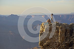 Young woman resting on cliff after hiking, Grand Canyon