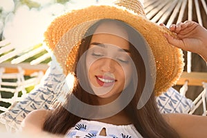 Young woman resting in comfortable hammock on sunny day, closeup