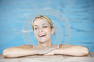 Young Woman Resting On Edge Of Swimming Pool