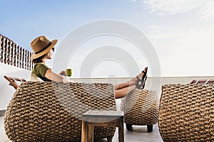 Young woman resting on hotel terrace. Vacations and summer fun concept. Beautiful girl enjoying life