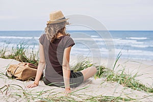 Young woman resting by the sea. Girl lying down on the beach. Enjoying life, summer lifestyle, relaxation and travel concept