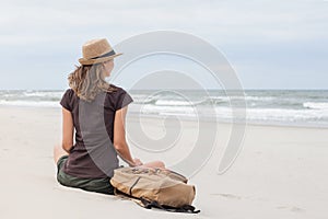 Young woman resting by the sea. Girl lying down on the beach. Enjoying life, summer lifestyle, relaxation and travel concept