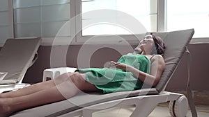 A young woman resting on a sun lounger in a Turkish bath.