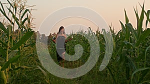 Young woman with a retro camera runs in the fields