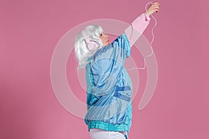 Young woman with retro clothes listening to music and dancing