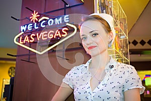 Young woman in retro dress near neon signboard in photo