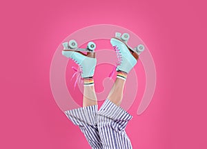 Young woman with retro roller skates on color background