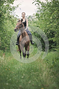 Young woman ridding on a horse