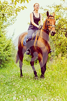 Young woman ridding on a horse