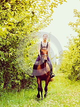 Young woman ridding on a horse