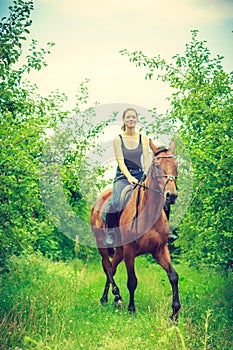 Young woman ridding on a horse