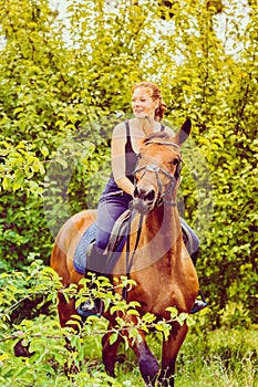 Young woman ridding on a horse