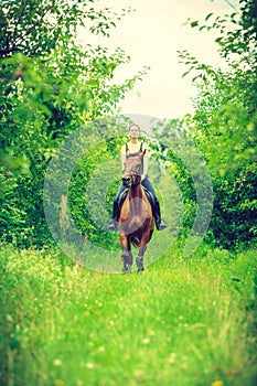 Young woman ridding on a horse