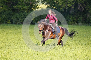 Young woman rides bay horse without holding bridle