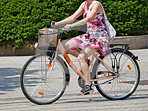 Young woman rides a bicycle on the city street