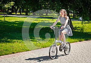 Young woman rides bicycle in the park