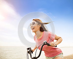 Young woman riding bicycle on the beach